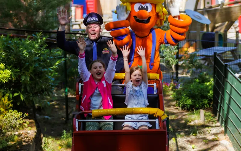 Kinderen en mascotte Twekky in de Rodelbaan bij Attractiepark De Waarbeek
